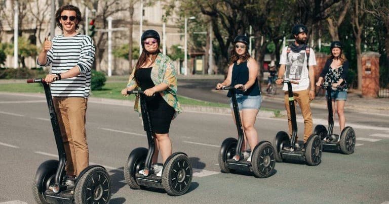Group riding Segways on a tree-lined city street during a tour
