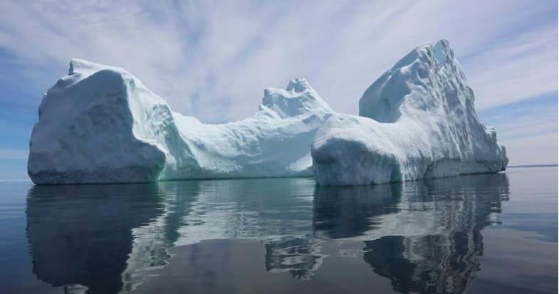 Icebergs reflecting on calm Arctic waters, glacier sightseeing cruise