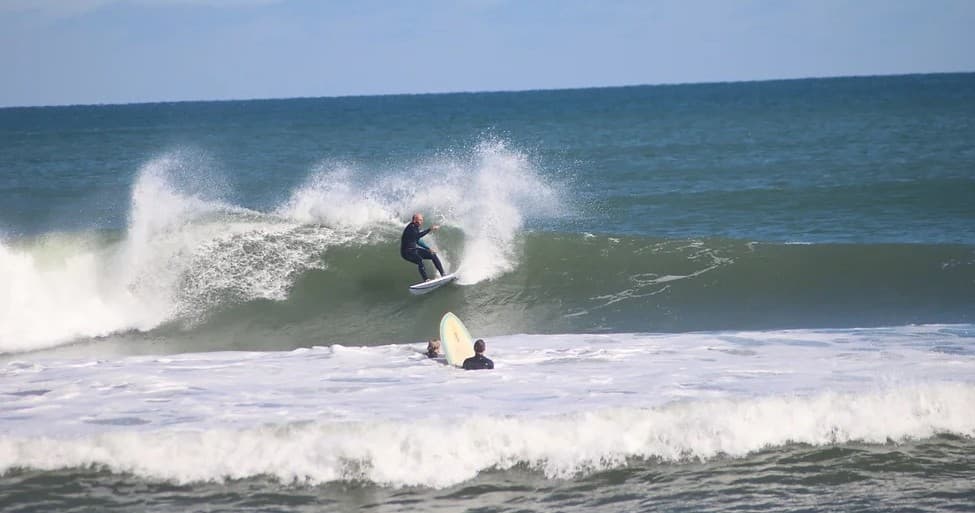 Surfer carving a wave with spray on open ocean shorebreak