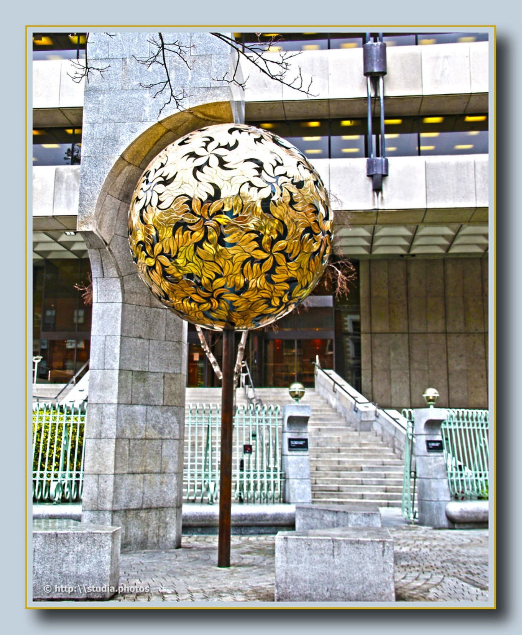 Urban public art golden globe sculpture by modern office plaza