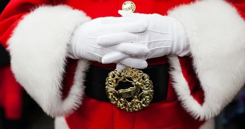 Santa costume belt and gloved hands close-up holiday portrait