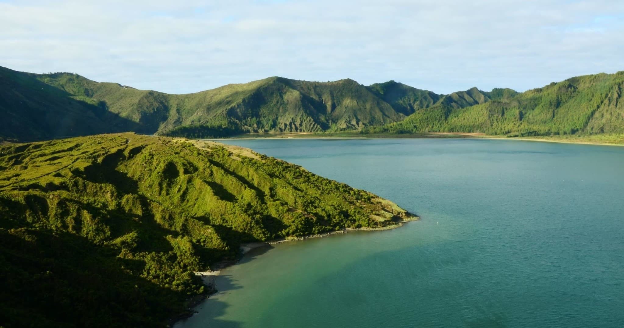 Panoramic crater-lake vista with hiking trails and volcanic rim