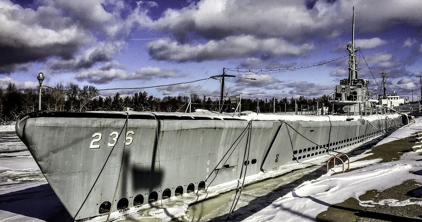 Historic WWII submarine docked in snow at outdoor museum tour