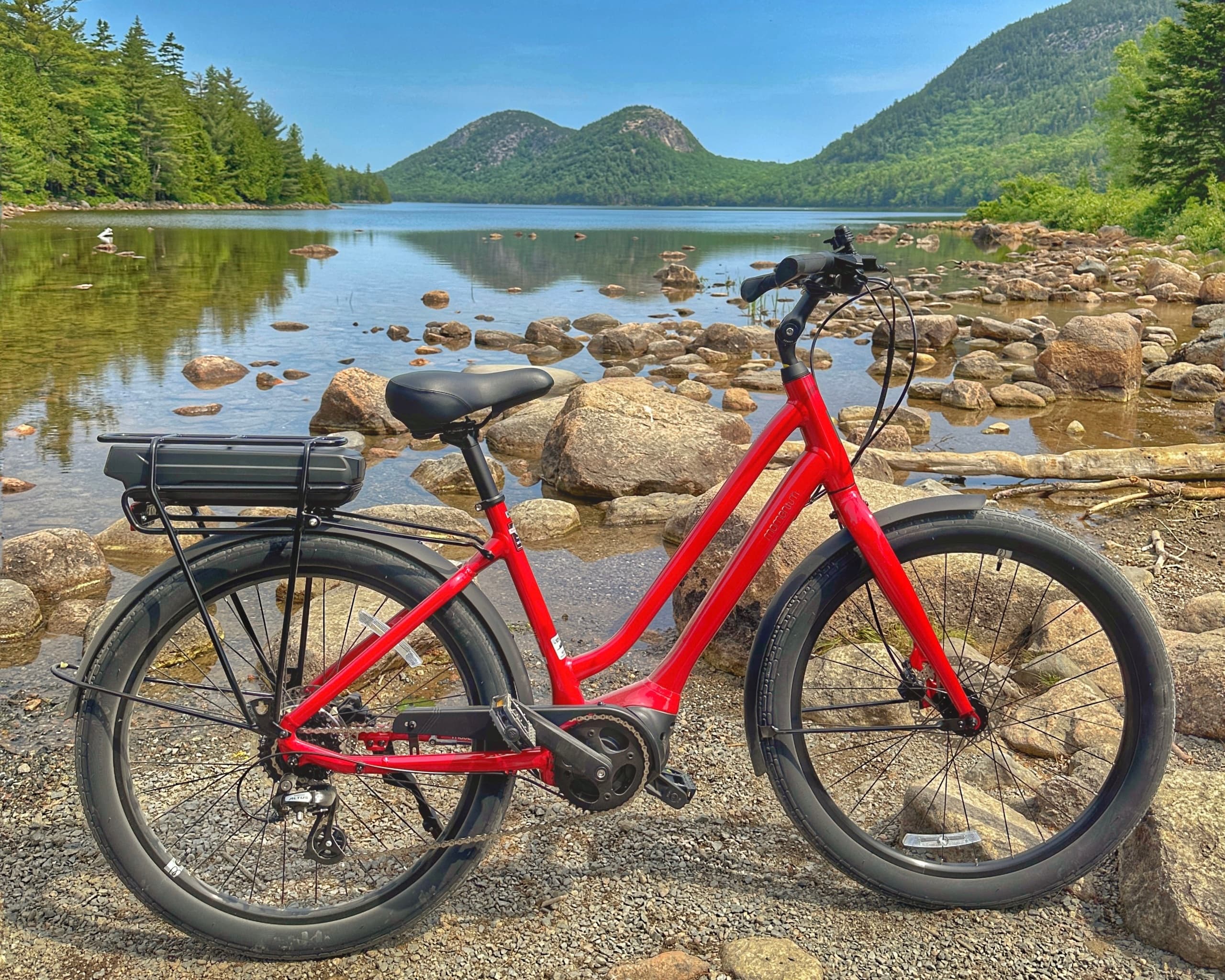 Electric bike parked on rocky shore with Acadia mountain views