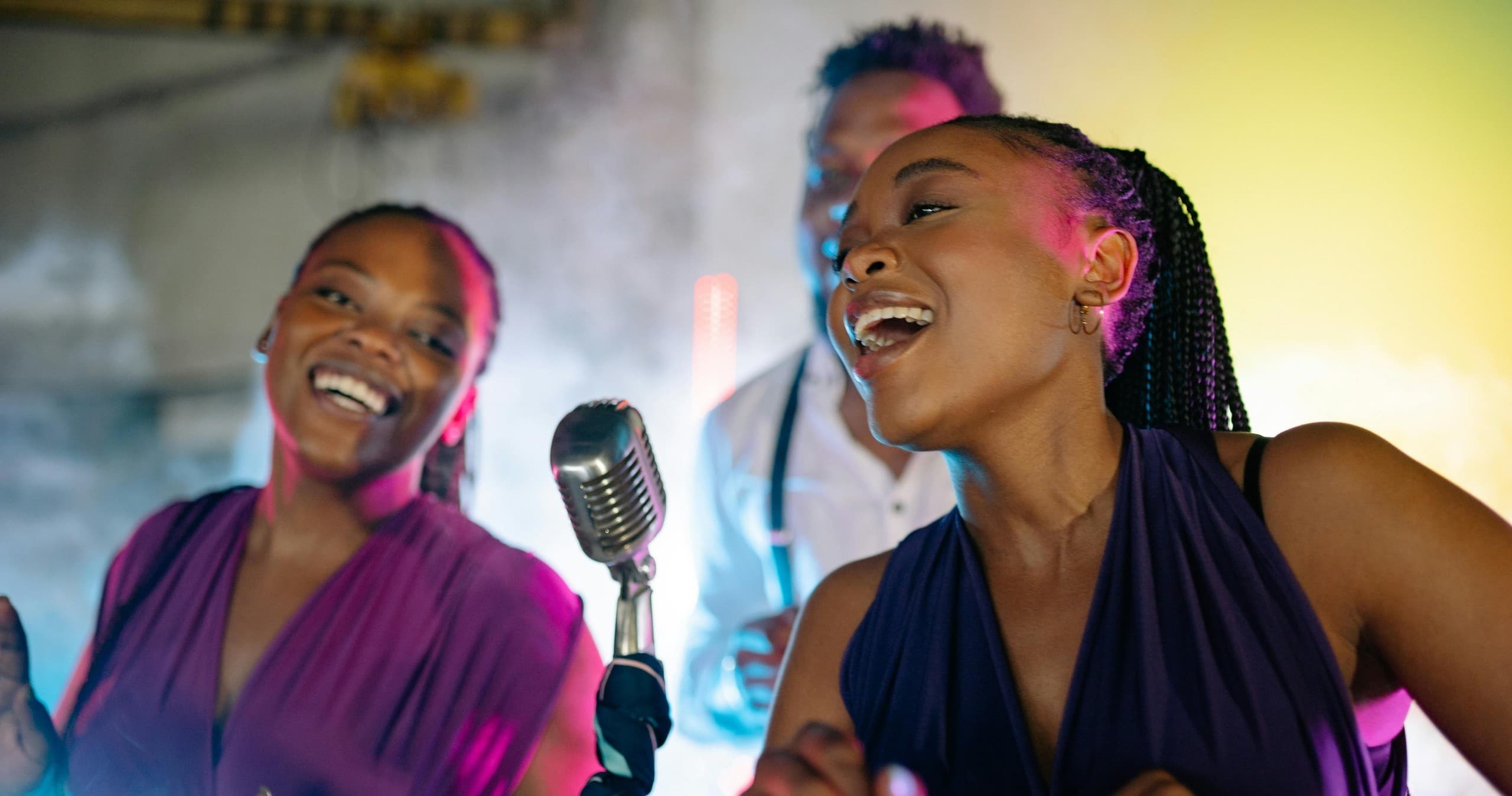 Singers performing on colorful indoor stage at live music event