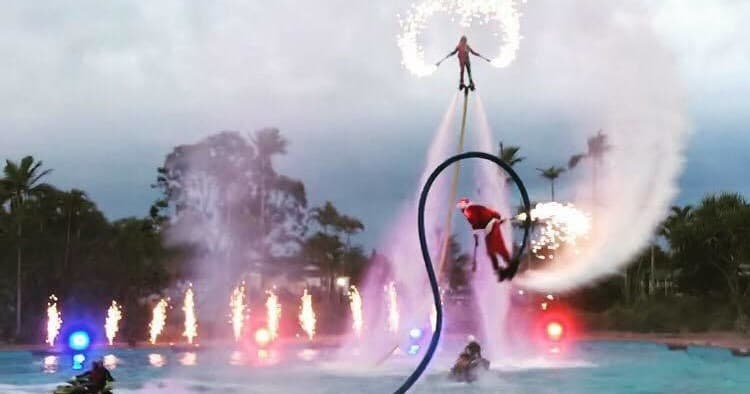 Nighttime flyboarding show with pyrotechnics over water