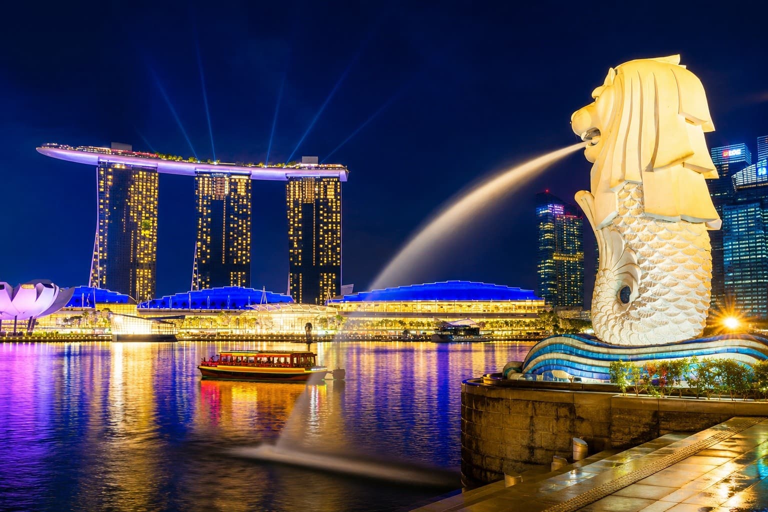 Merlion fountain spraying with Marina Bay Sands skyline at night