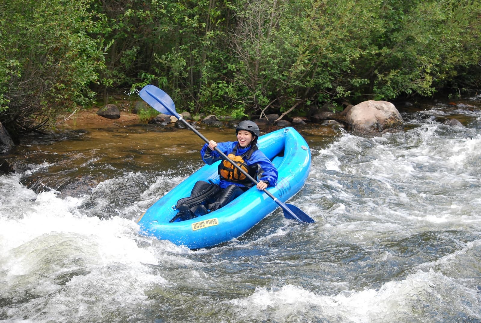 Solo kayaker navigating whitewater rapids in mountain stream