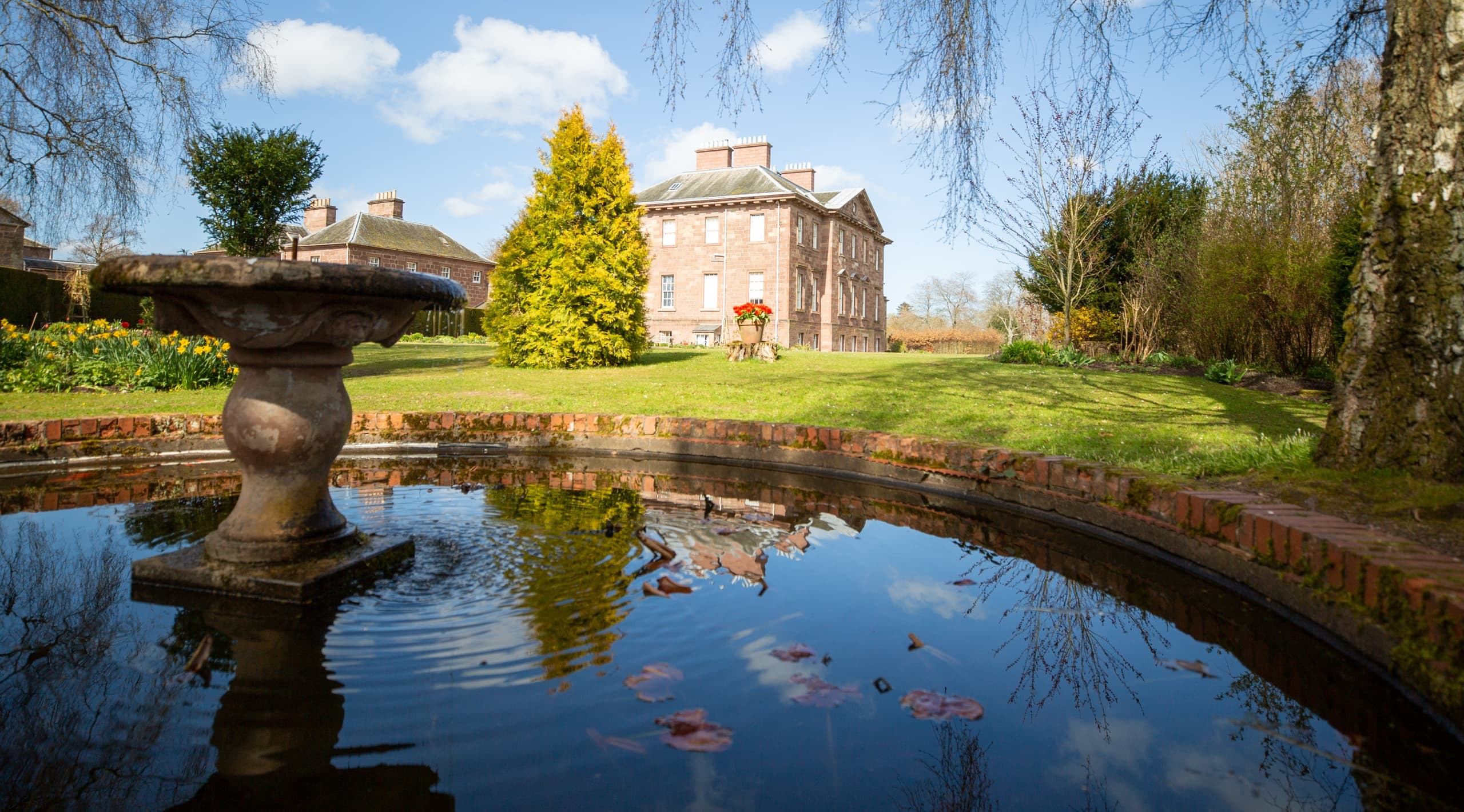 Historic house reflected in estate pond at Paxton House gardens
