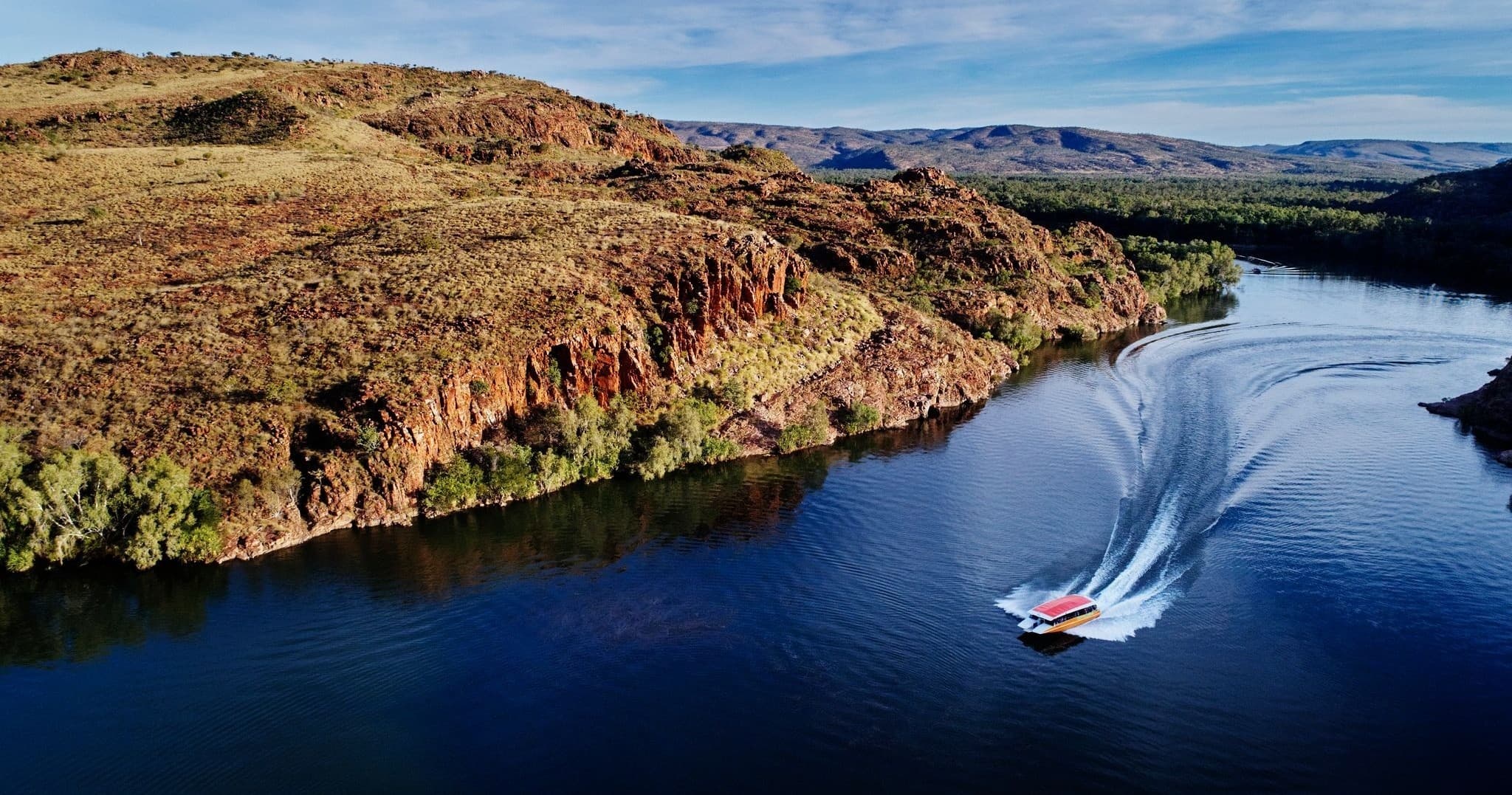 Speedboat cruising a winding river through rugged gorges