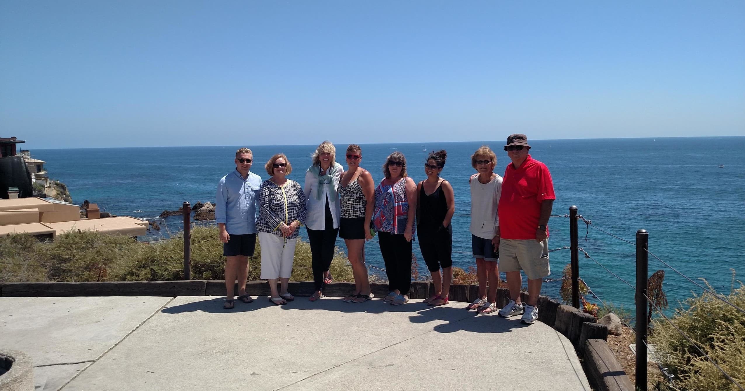 Group posing on seaside cliff with Pacific Ocean vista