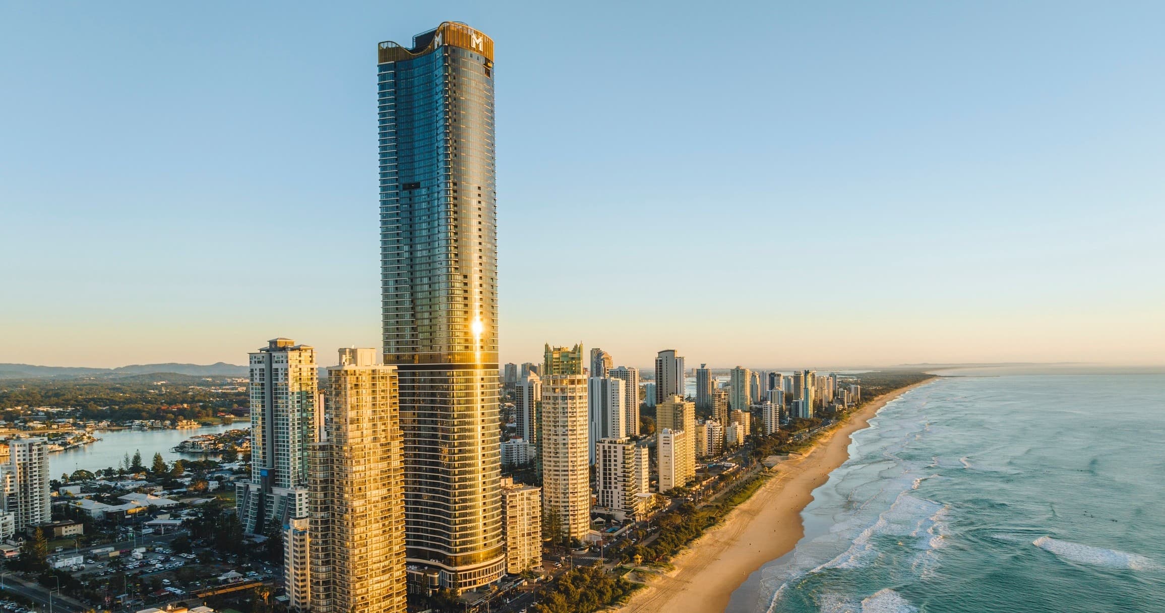 Aerial coastal skyline at sunset showcasing high-rise beachfront