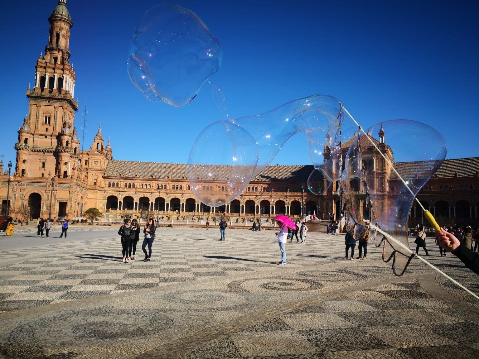 Plaza de España Seville with street performer making giant bubbles