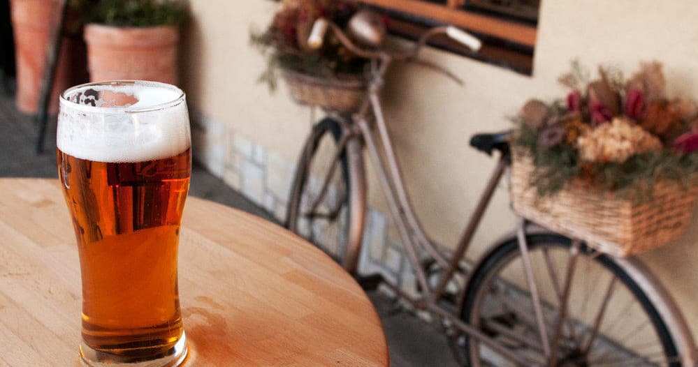 Outdoor craft beer pint on patio with vintage bike in Houston