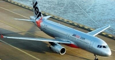 Commercial airliner parked on tarmac at coastal airport