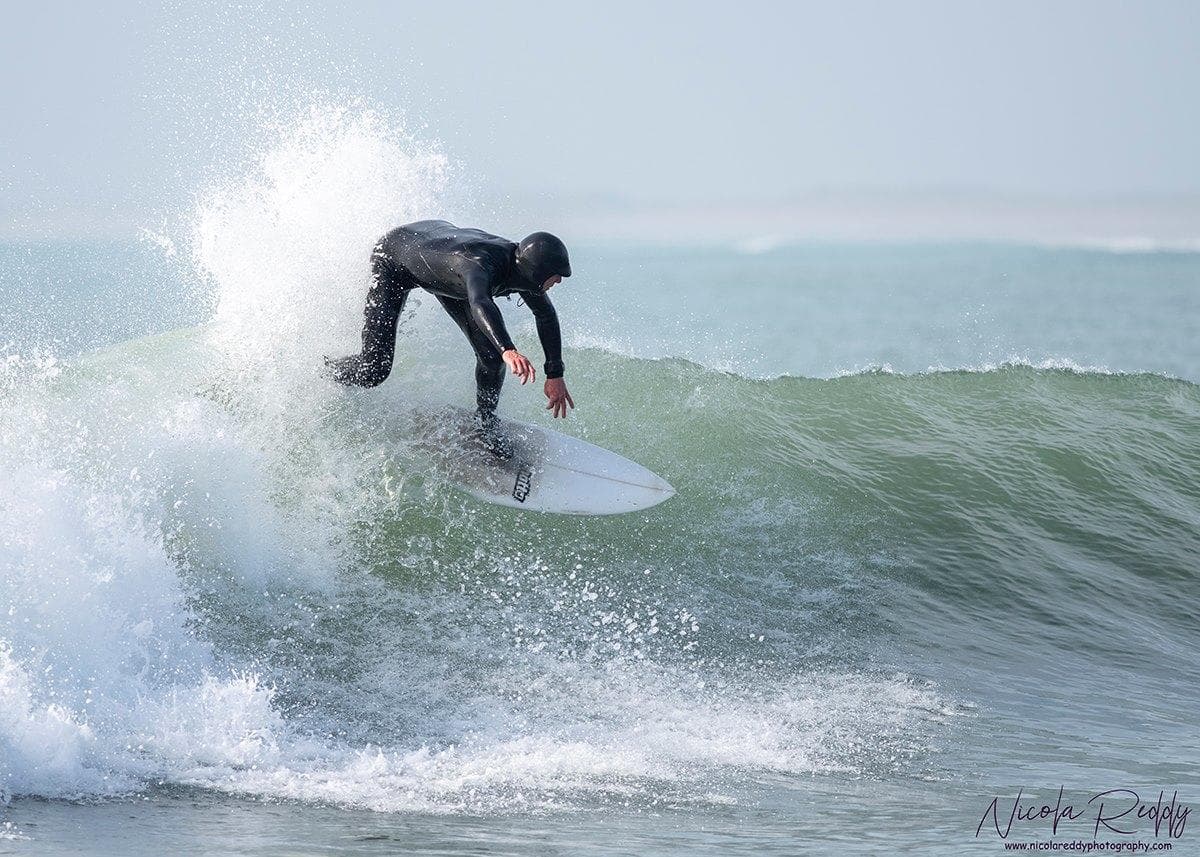 Surfer carving a powerful turn on a green ocean wave