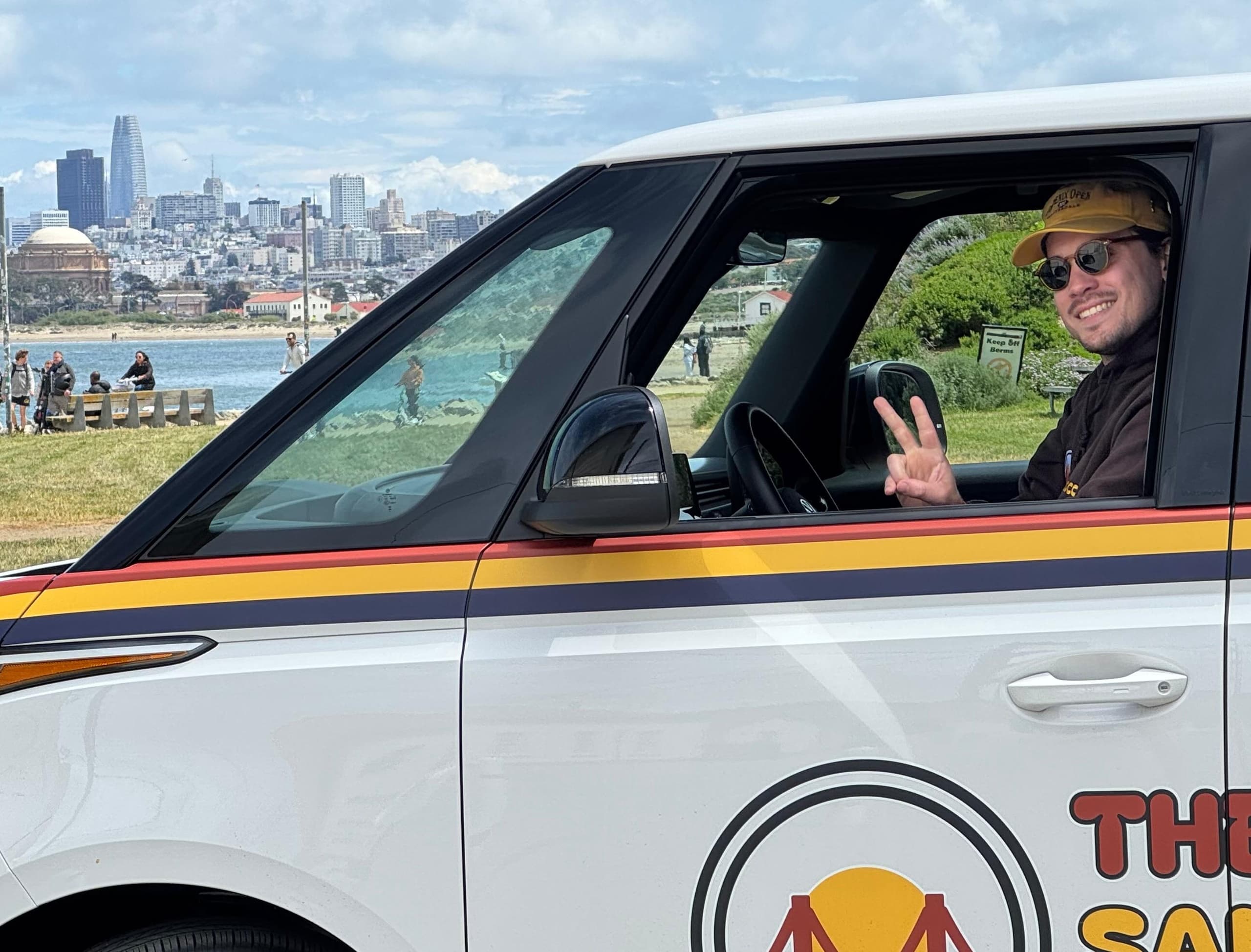 Driver waving from San Francisco sightseeing van near waterfront