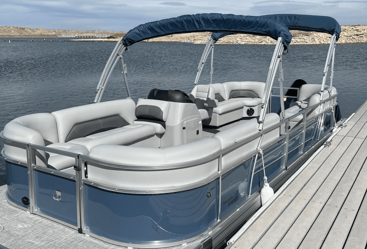 Blue pontoon boat docked on calm reservoir, scenic family cruise