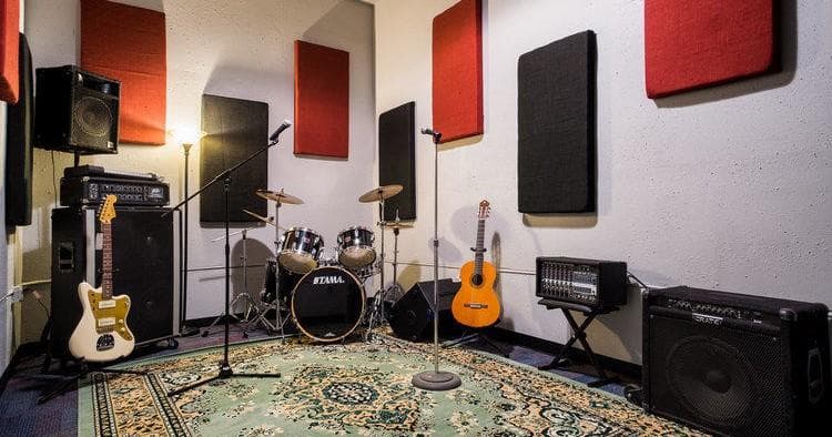Rehearsal studio interior with drum kit, guitars and amps