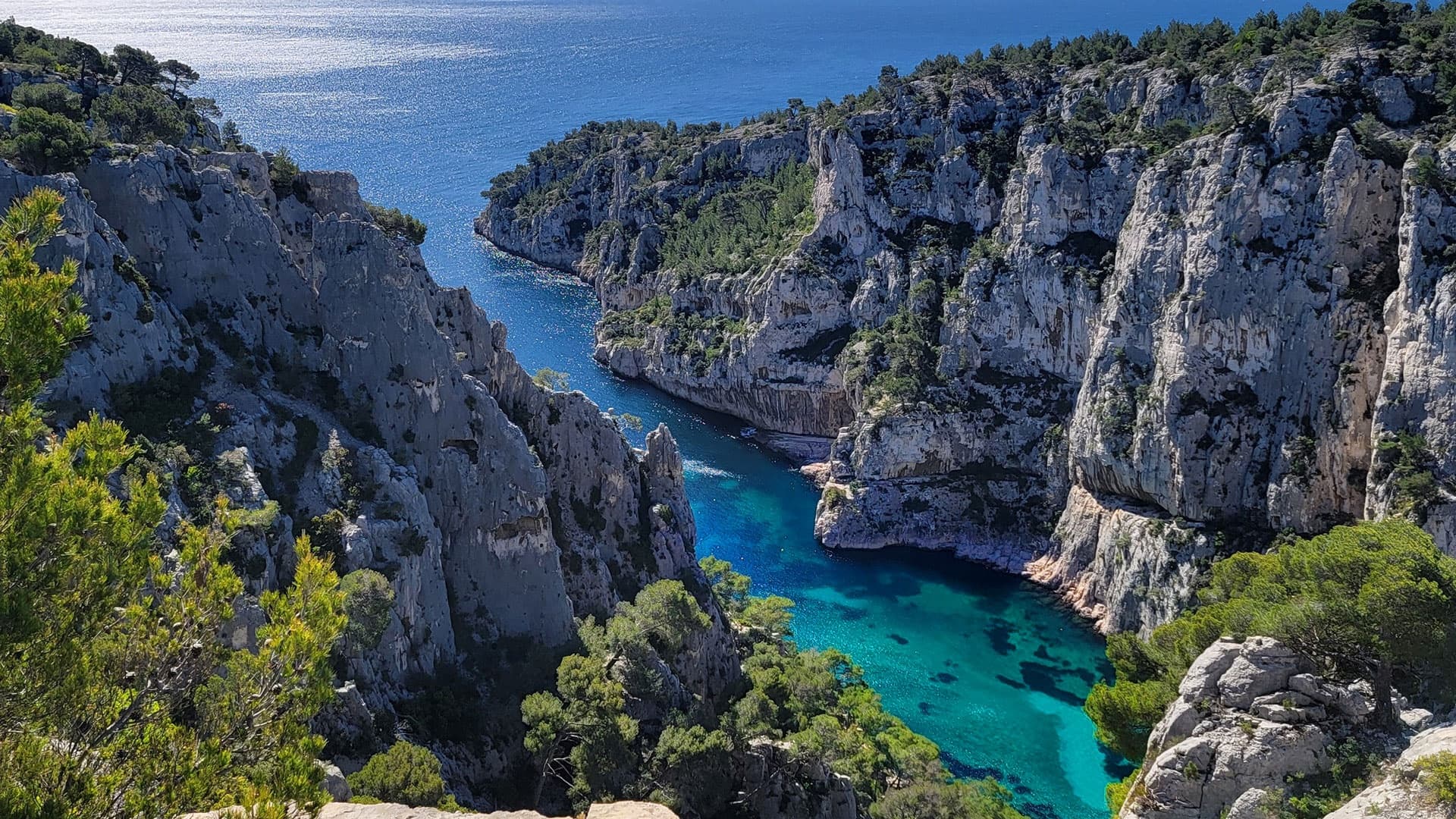 Kayaking in Mediterranean calanque with turquoise cliff inlet