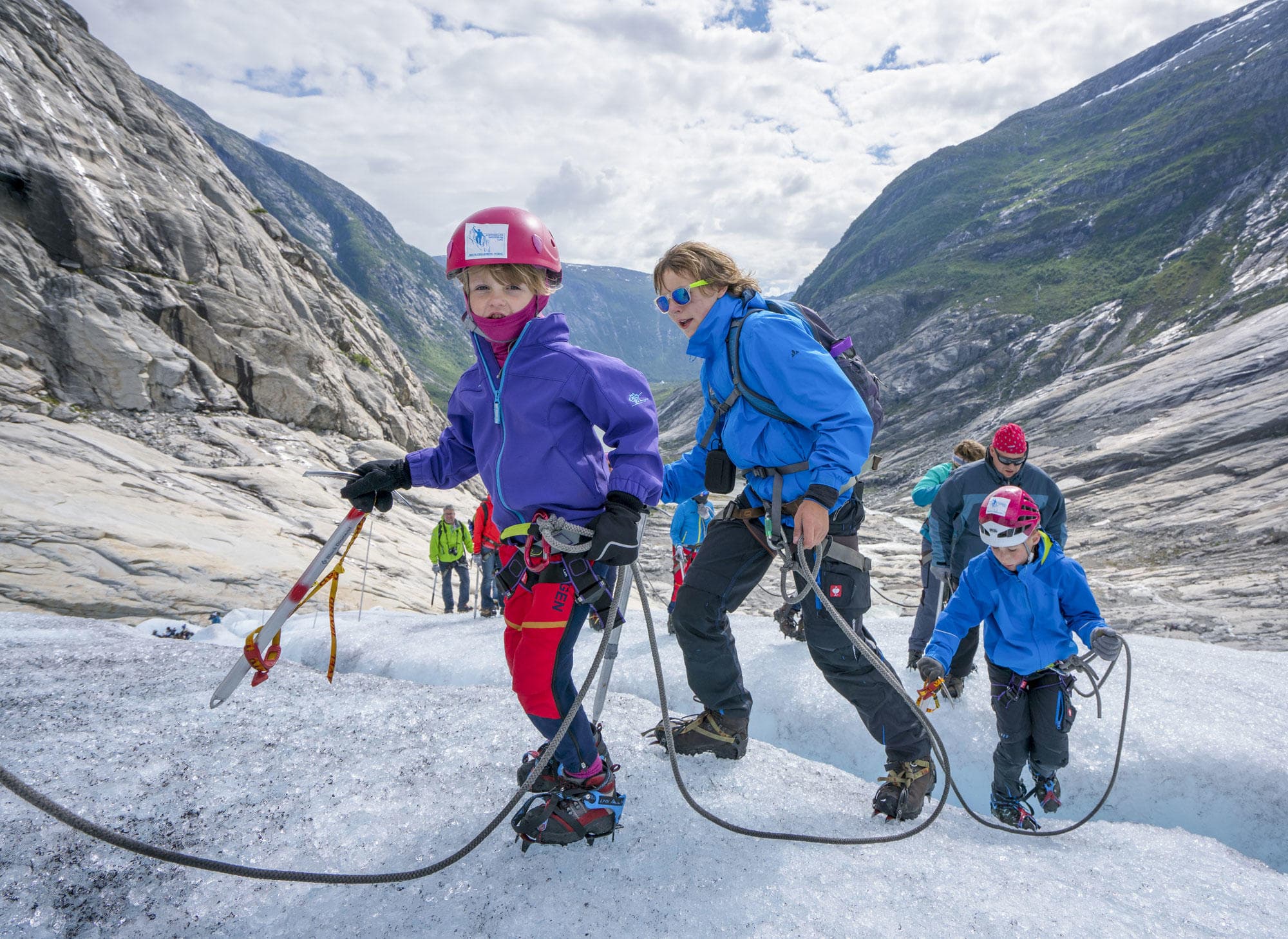 Guided glacier hike across icy valley with rope team