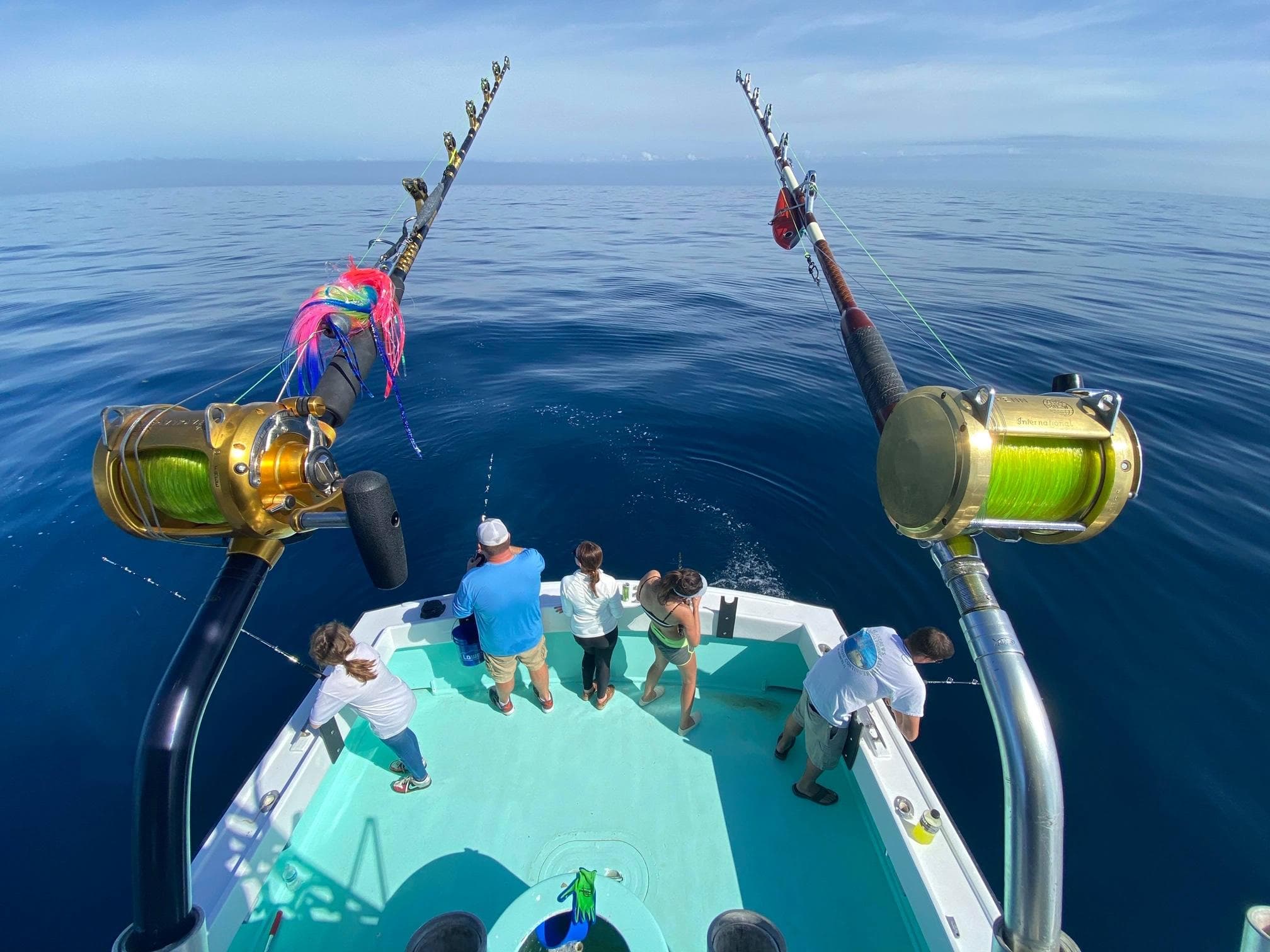 Anglers fishing from stern with heavy tackle over deep blue sea