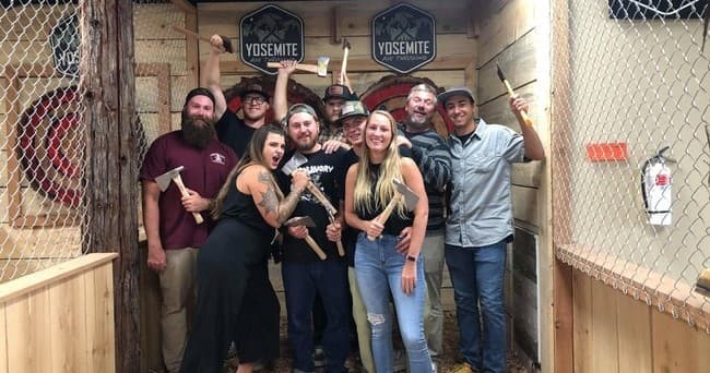 Group posing with axes at indoor Yosemite Axe Throwing Big Bear