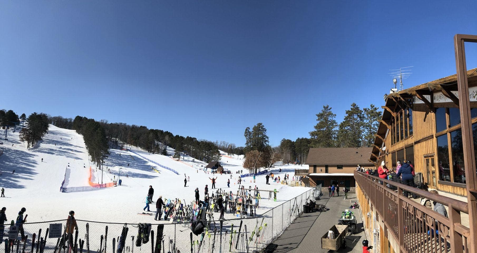 Panoramic ski resort slopes and lodge under clear blue sky