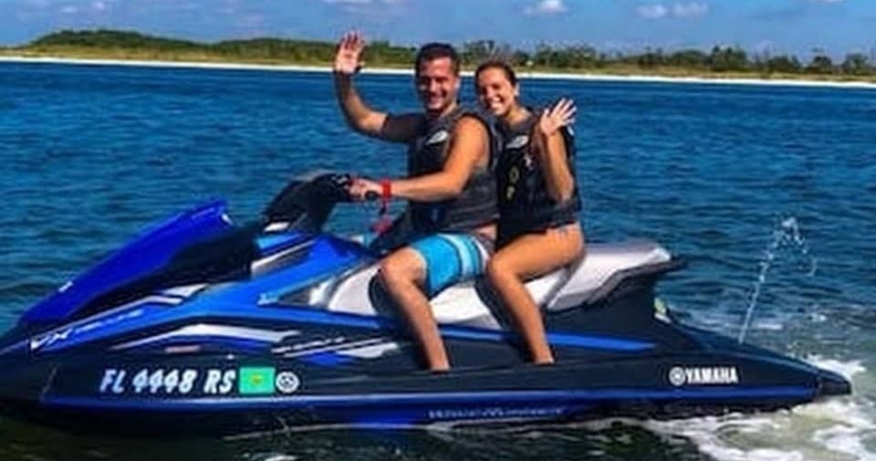 Couple riding Yamaha jet ski on coastal ocean waters