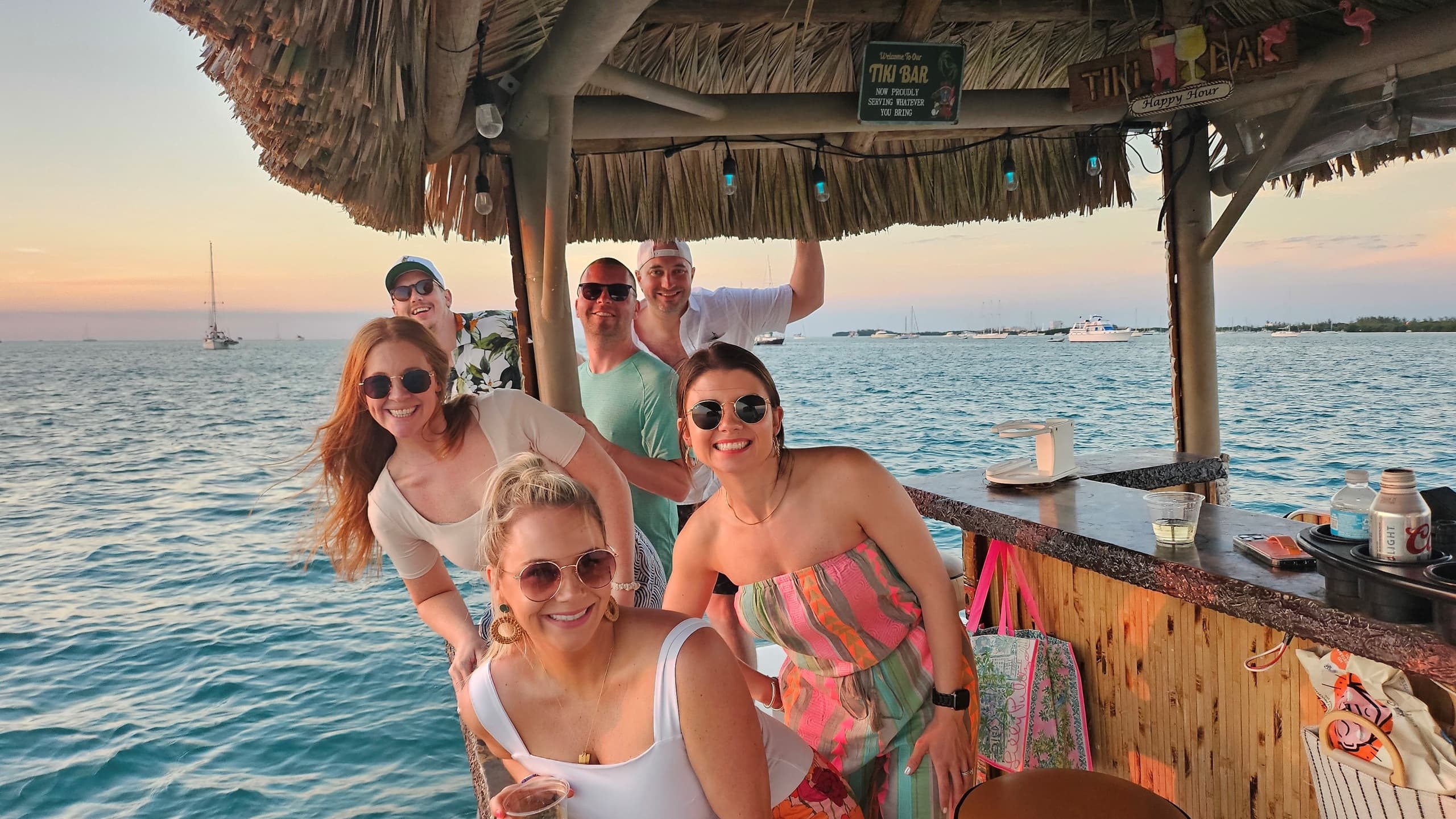 Sunset boat party with friends at tiki bar on the water