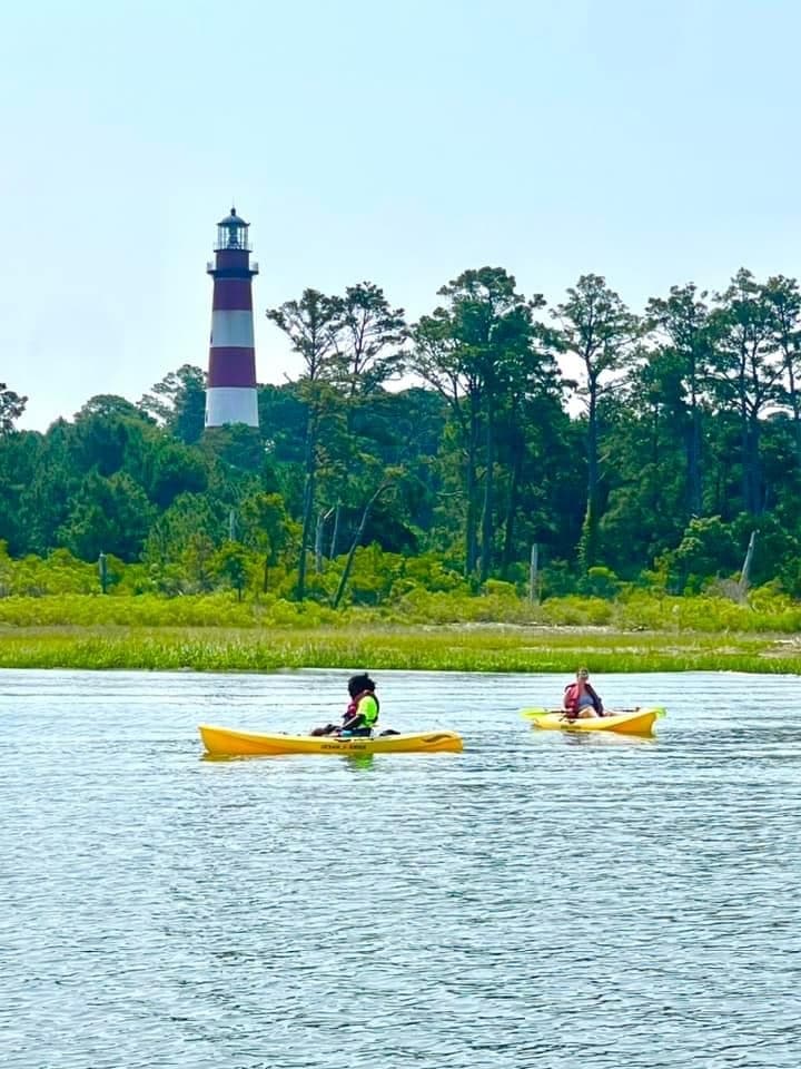 Kayakers paddling near Chincoteague lighthouse in coastal waters