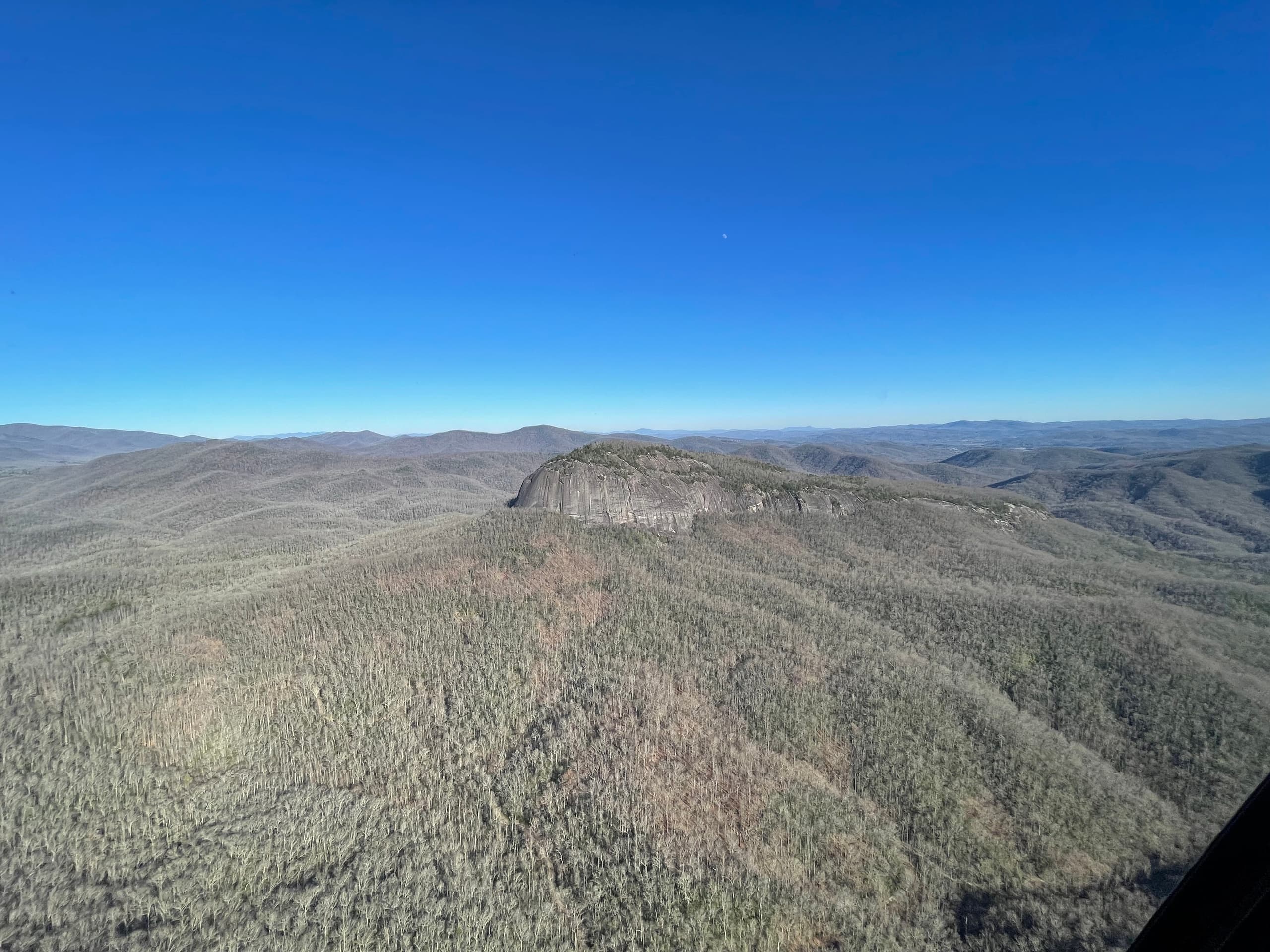 Scenic helicopter flight above rolling green hills and lakes