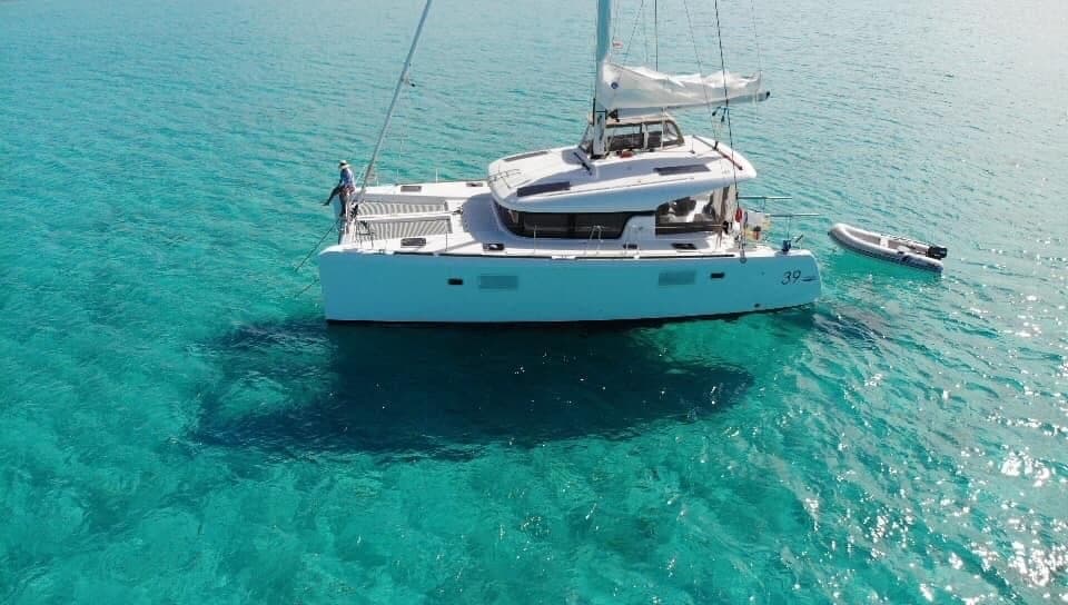 Aerial view of white yacht on turquoise sea near coastline