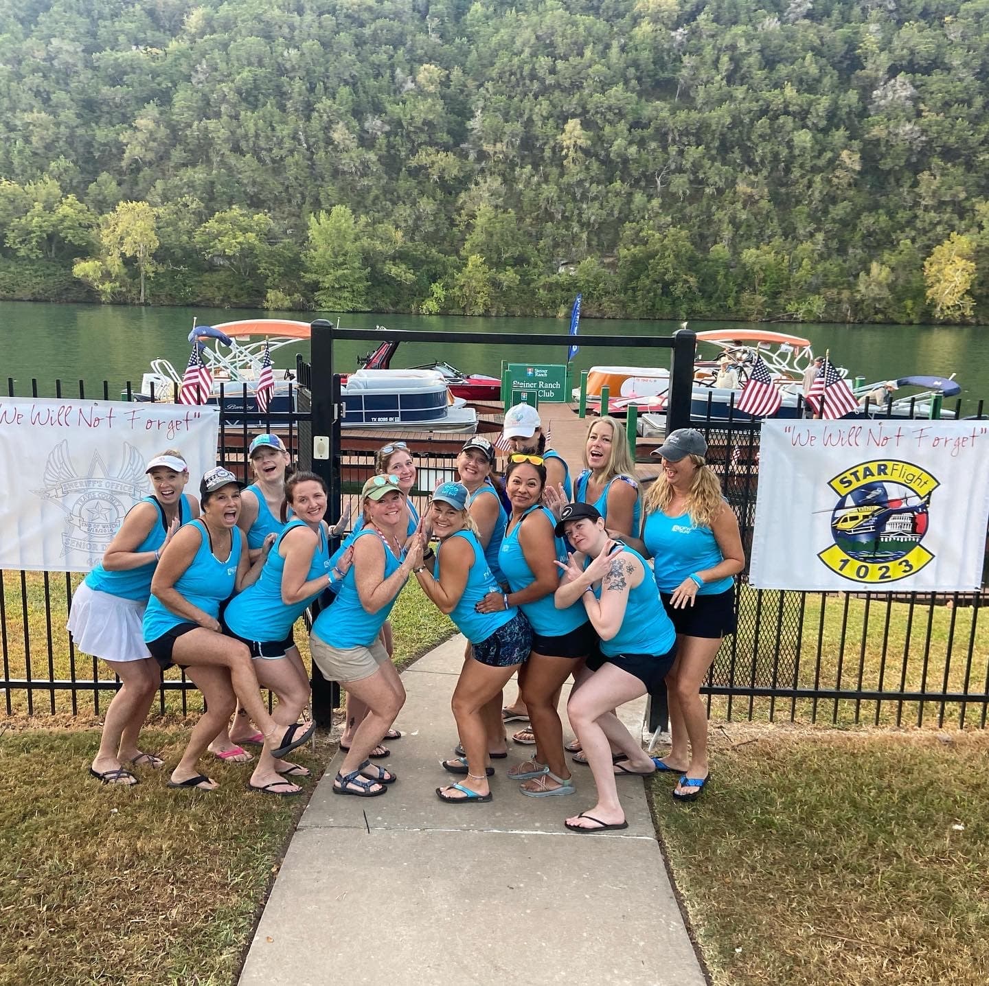 Group of female paddlers posing at riverside boat ramp during event