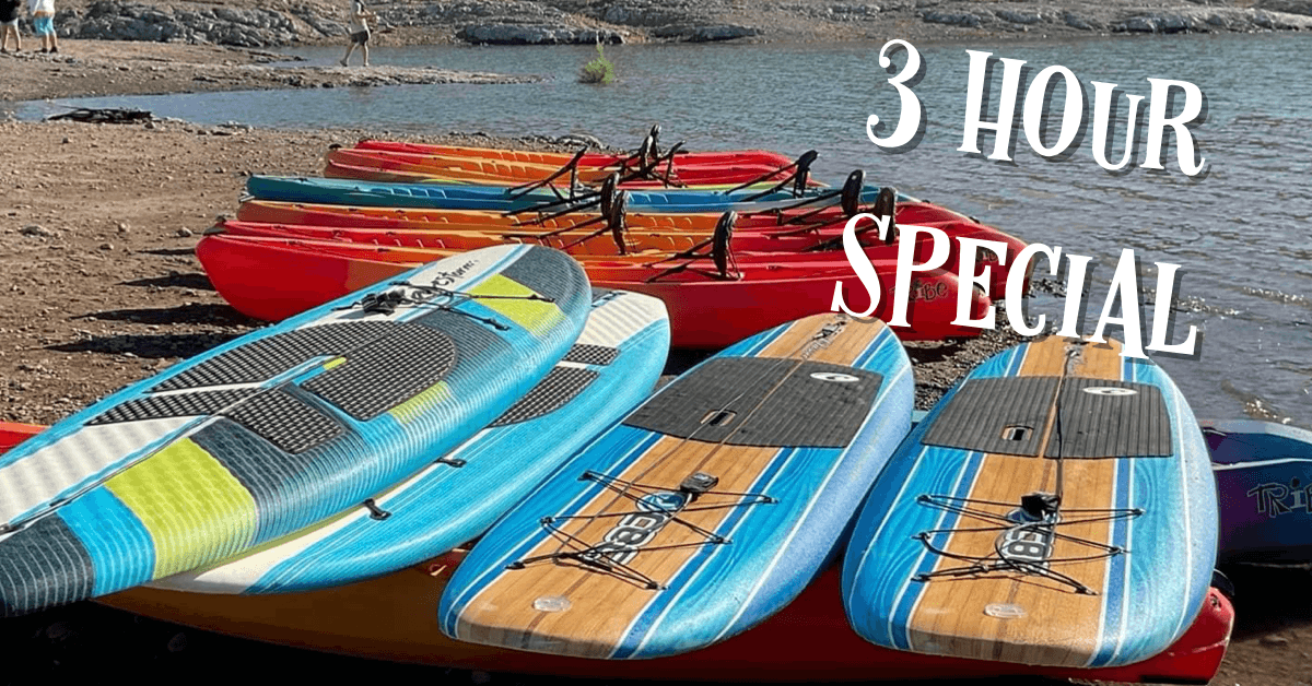 Colorful kayaks and SUPs on sandy beach at desert lake