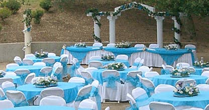 Outdoor wedding reception tables set with blue decor on lawn