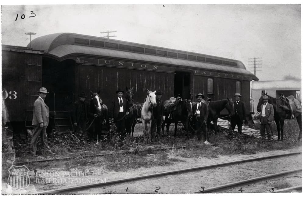 Vintage railroad scene with passengers and horses by train car
