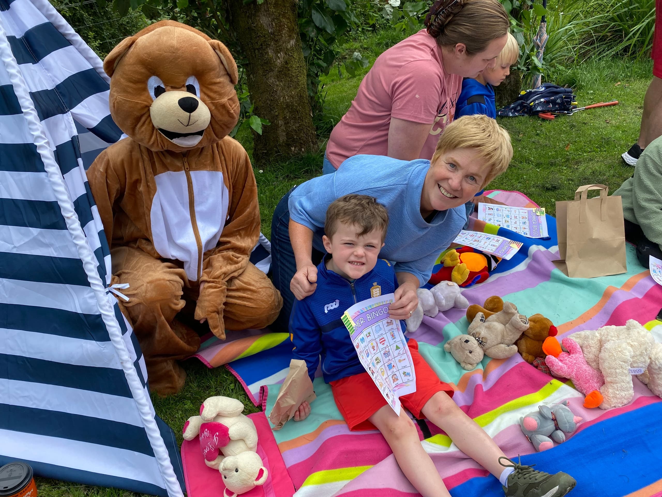 Family picnic with kids and activities on grassy greenway