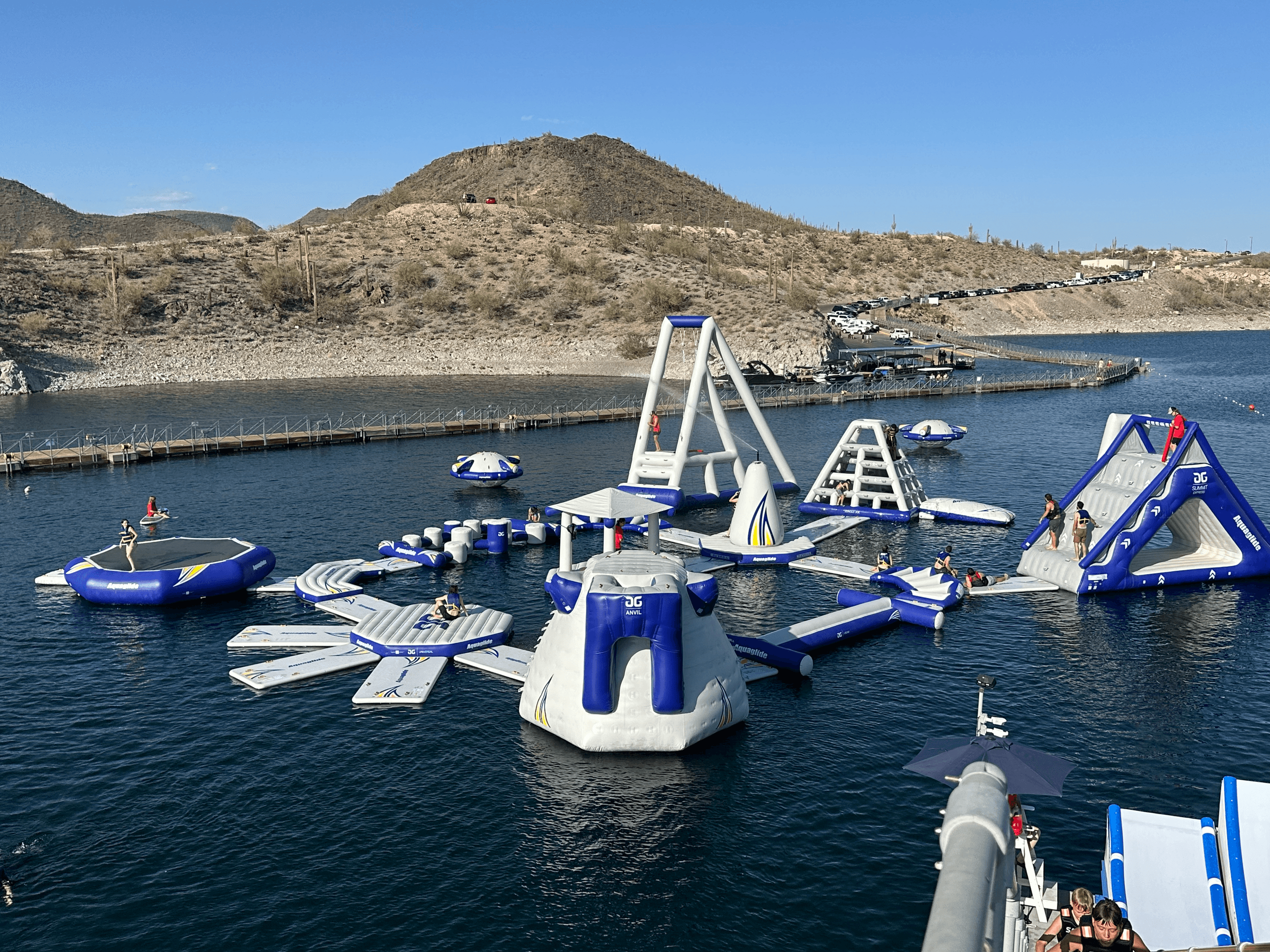 Floating waterpark on lake with inflatable course and mountains