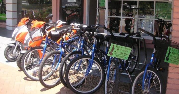 Row of beach cruiser bicycles lined up outside rental shop