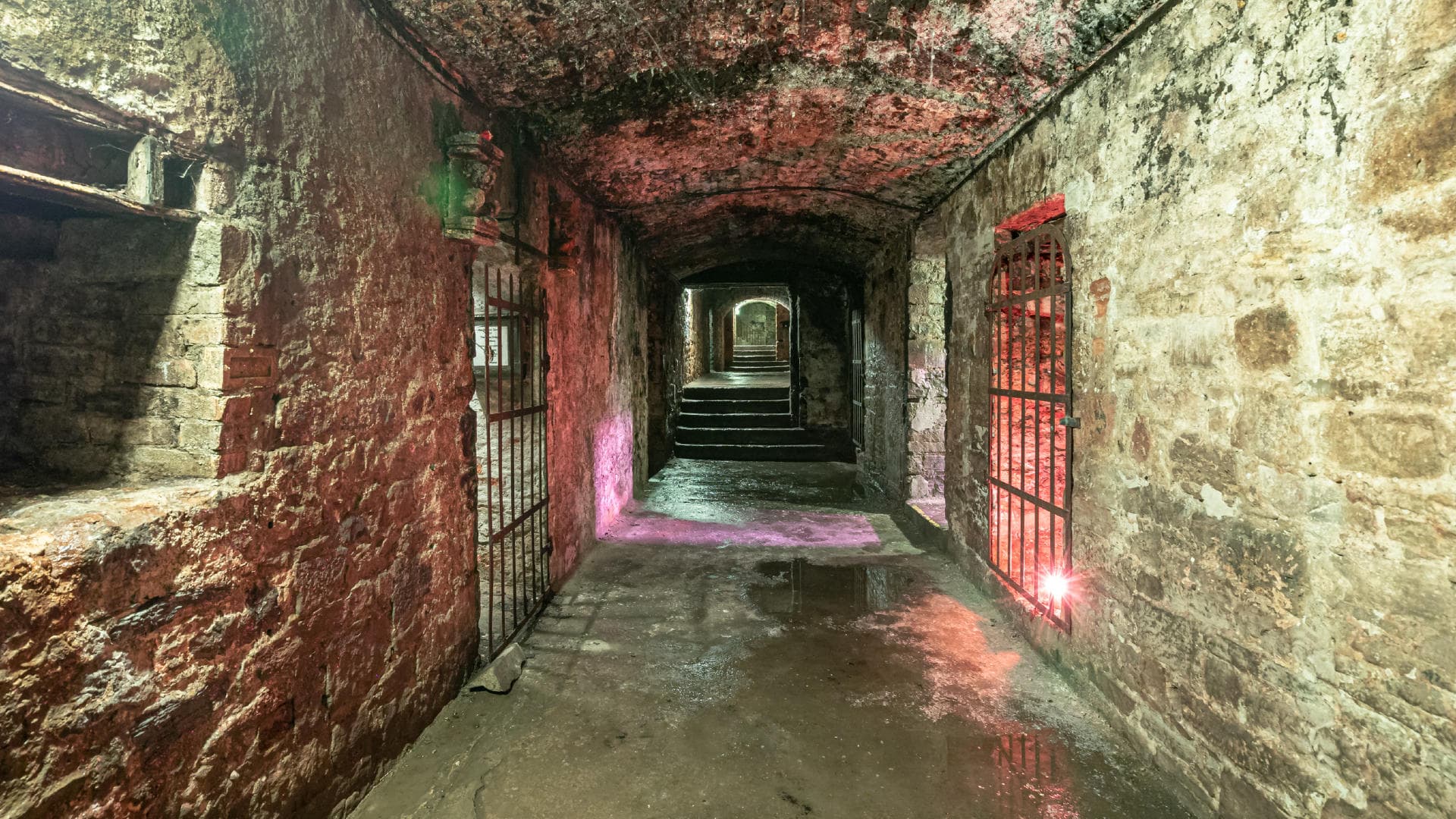 Stone underground passage with colored lights in historic vaults