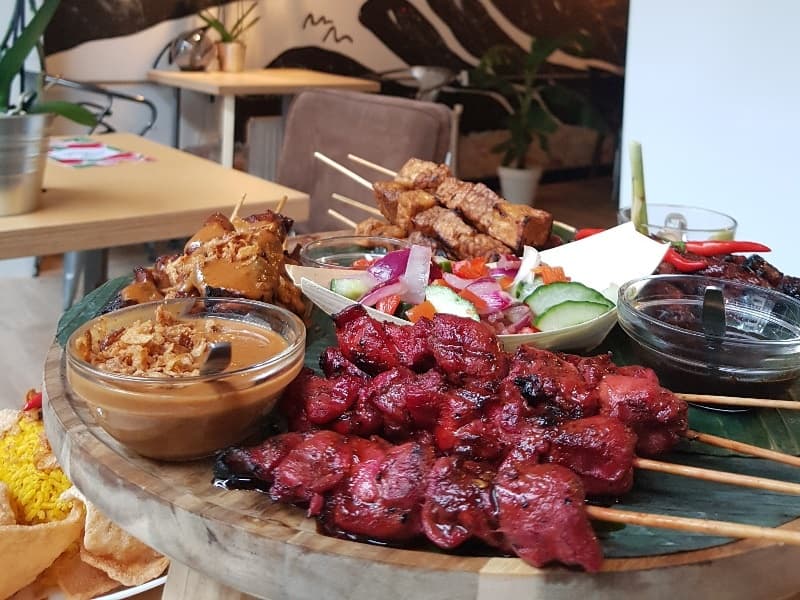 Grilled satay skewers platter in casual indoor restaurant