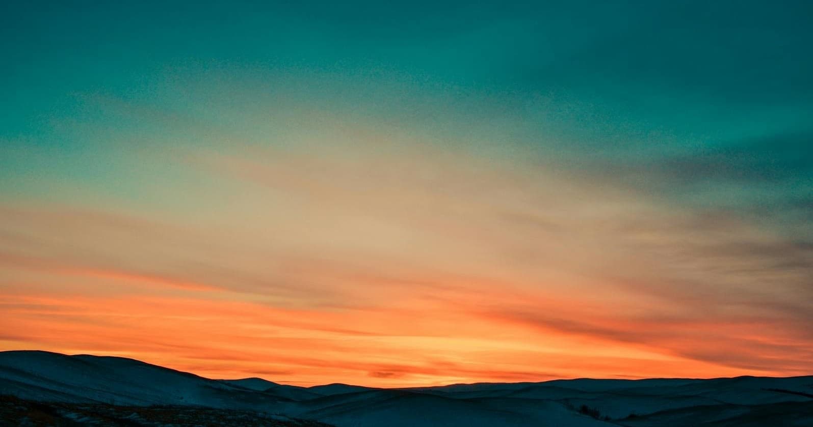 Colorful coastal sunset sky over calm ocean horizon