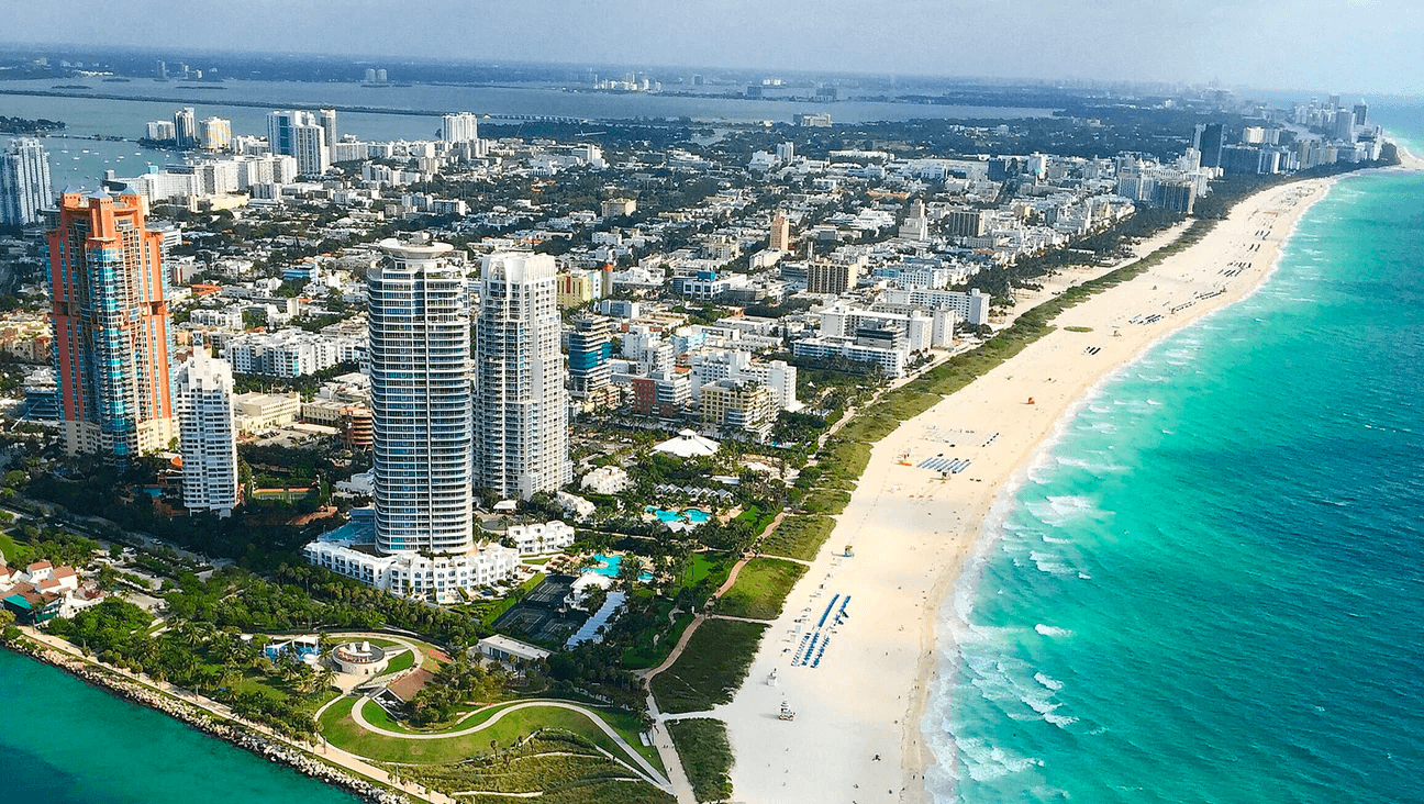 Aerial view of Miami Beach coastline with turquoise water, skyline