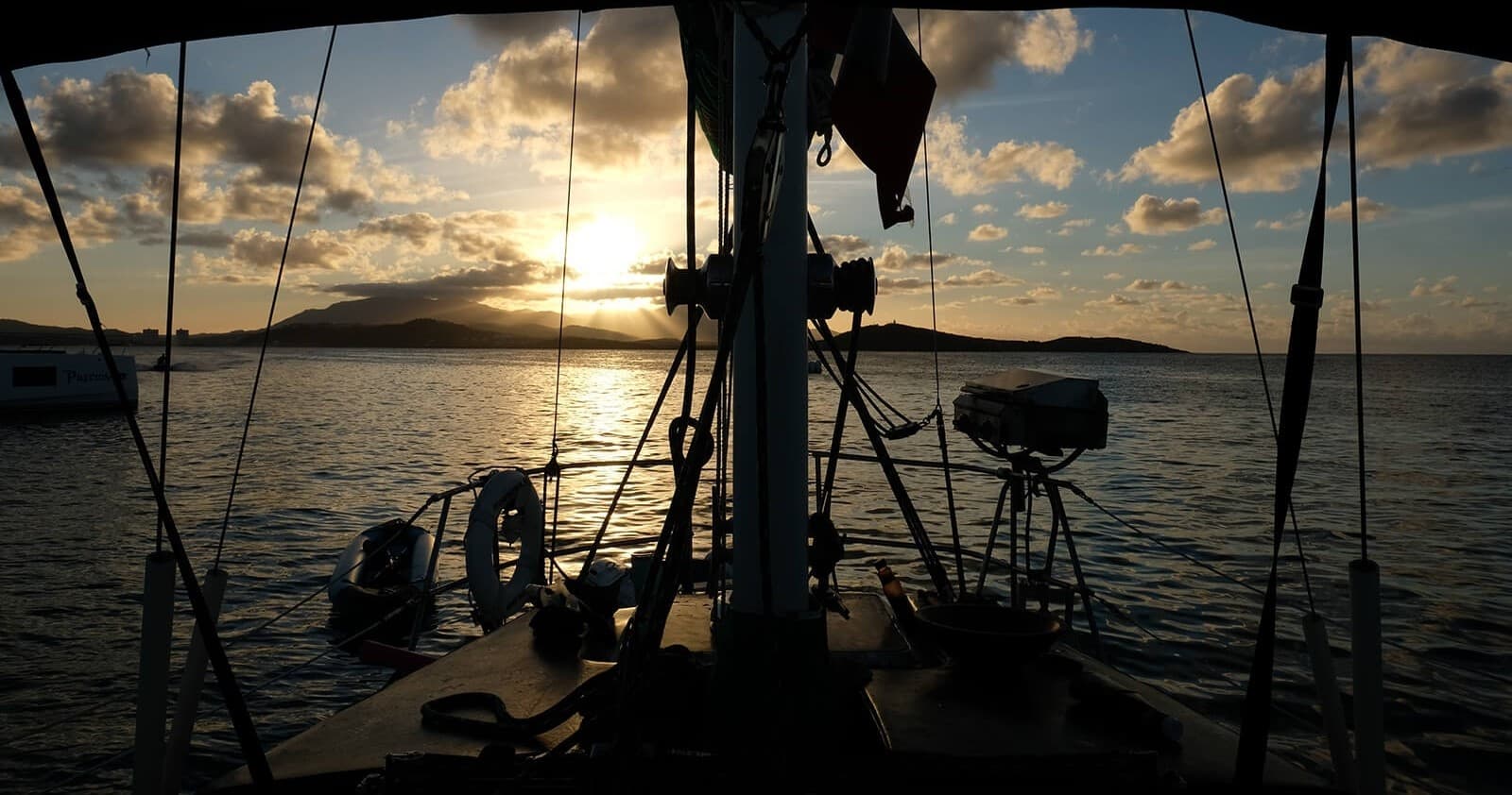 Sunset sail silhouette from cockpit on calm ocean