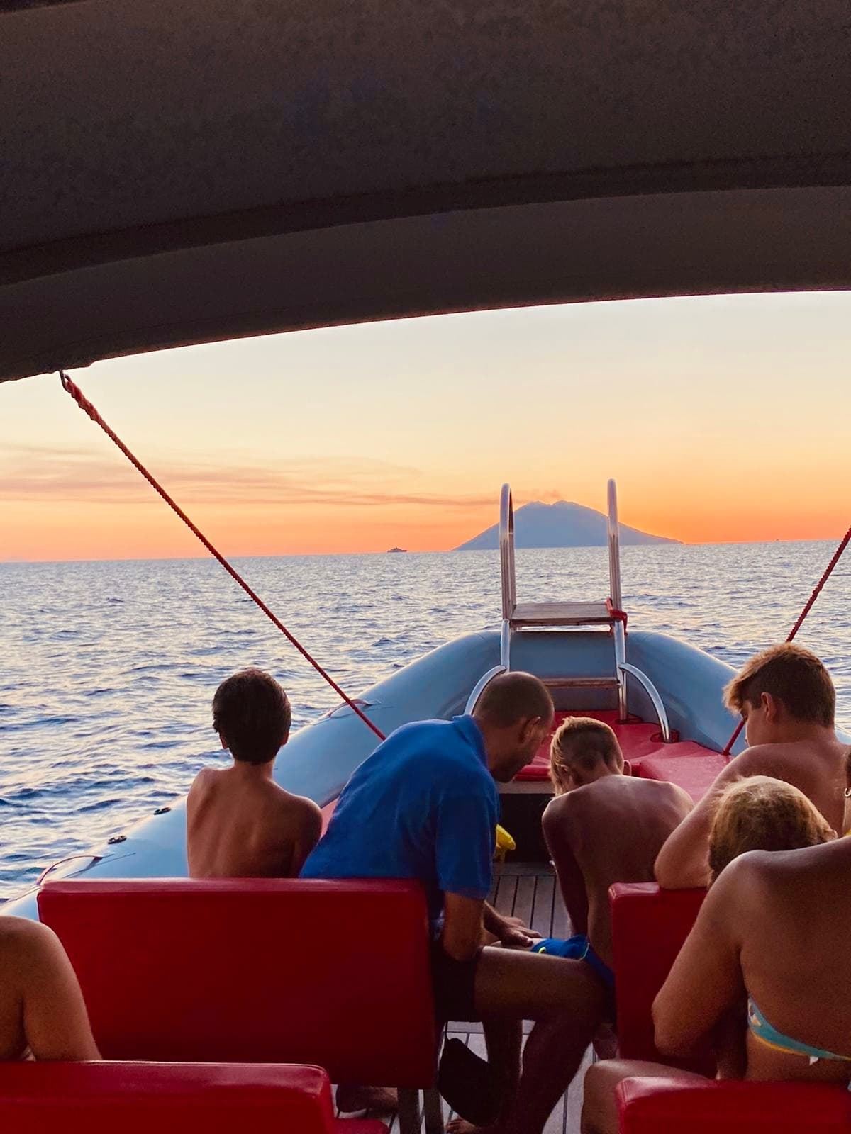 Sunset boat ride with passengers watching sea view off stern