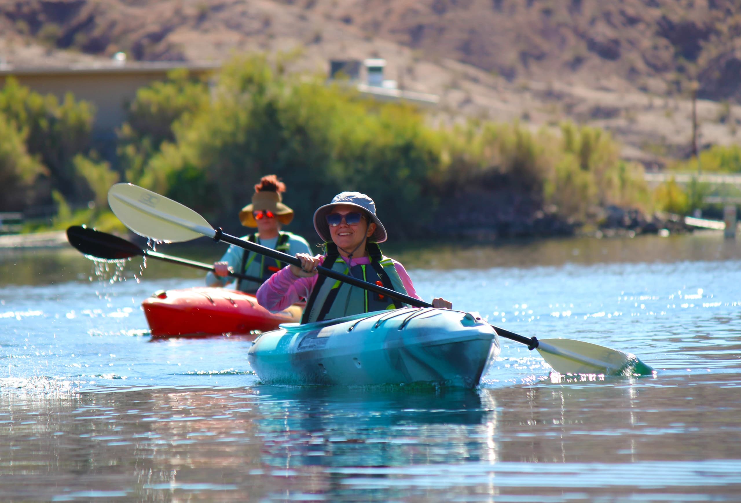 Solo kayaker paddling on calm river in desert canyon