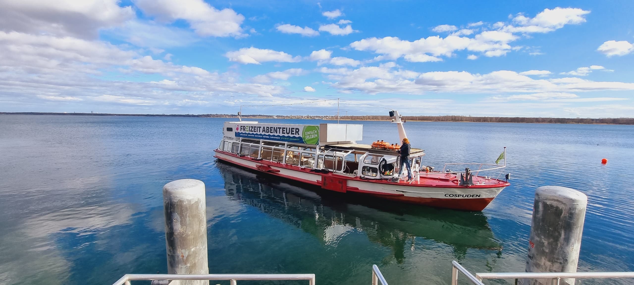Small passenger ferry moored at tranquil coastal harbor pier