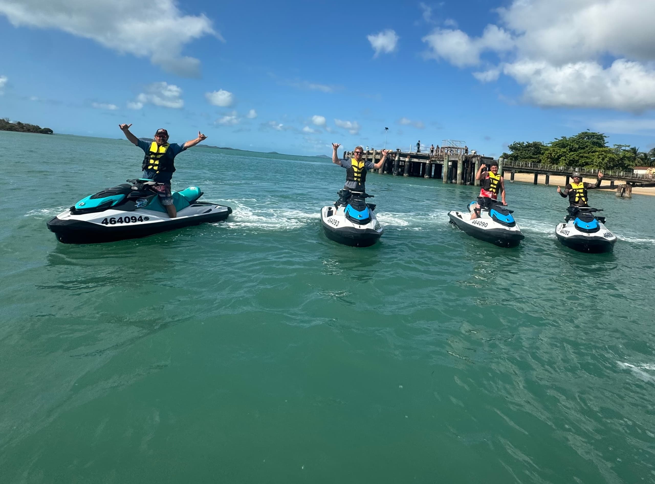 Jetski riders cruising turquoise coastal waters near Cape York pier