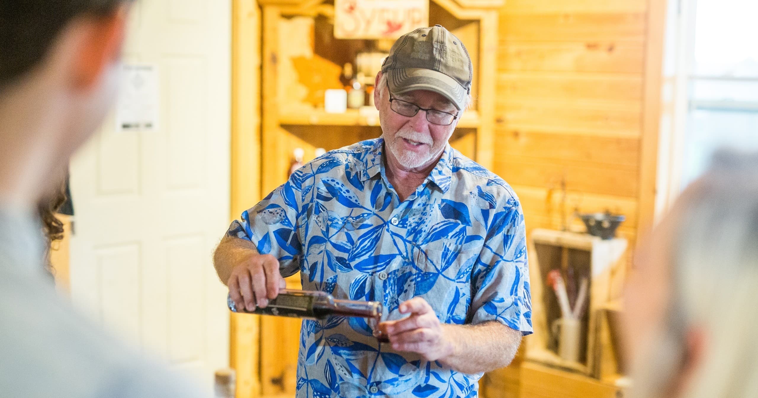Host pouring wine in cozy wooden tasting room, interactive demo